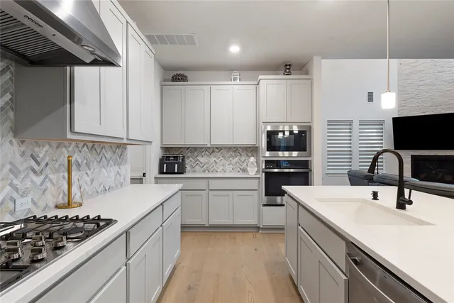 a kitchen with a sink stove and cabinets