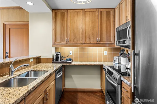 a kitchen with stainless steel appliances granite countertop a sink stove and cabinets