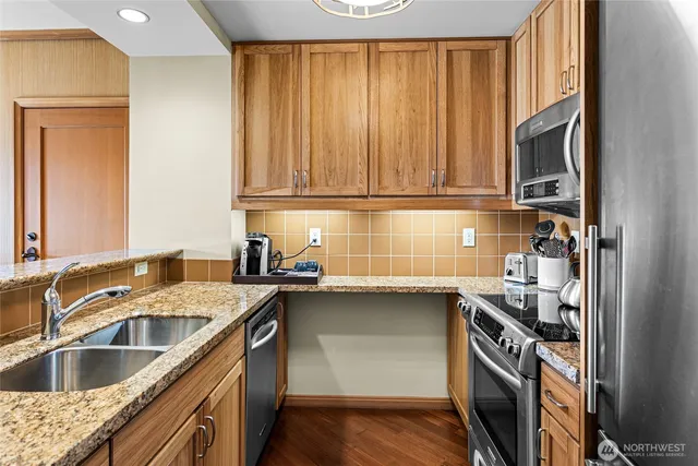 a kitchen with stainless steel appliances granite countertop a sink stove and cabinets