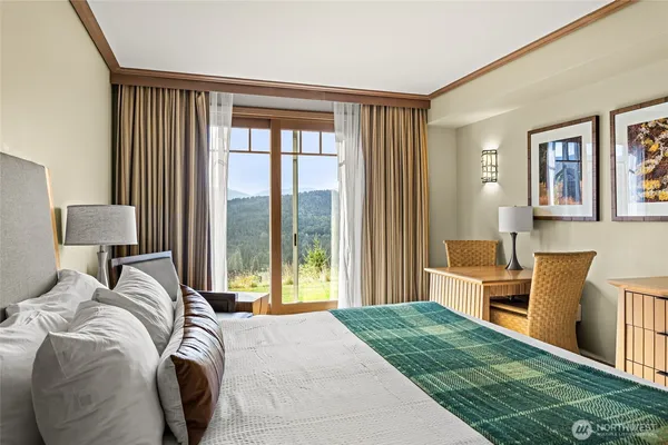 a bedroom with a bed and a large window
