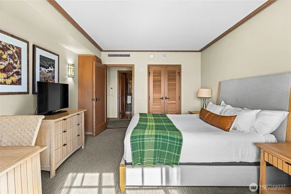 a bedroom with a bed and a flat screen tv