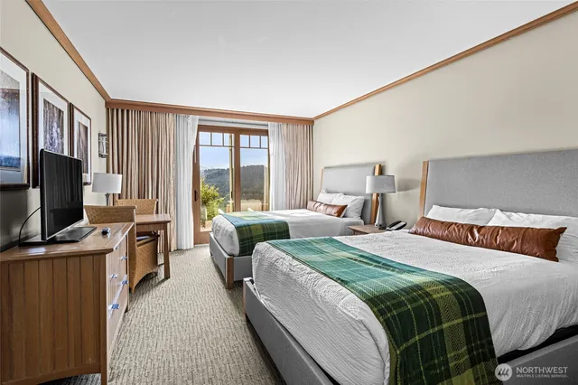 a bedroom with a bed and a flat tv screen on dresser