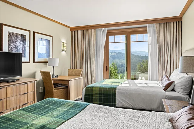 a bedroom with a large bed and a flat tv screen