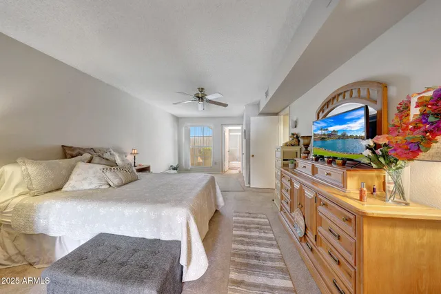 a bedroom with bed and a large mirror on the dresser