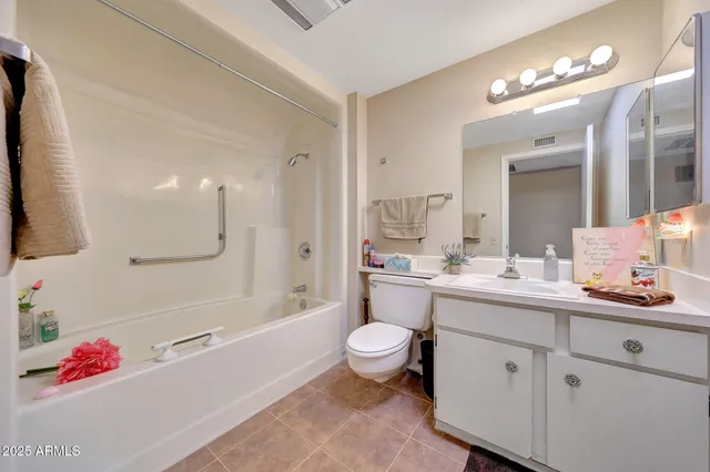 a spacious bathroom with a bathtub shower sink mirror and toilet