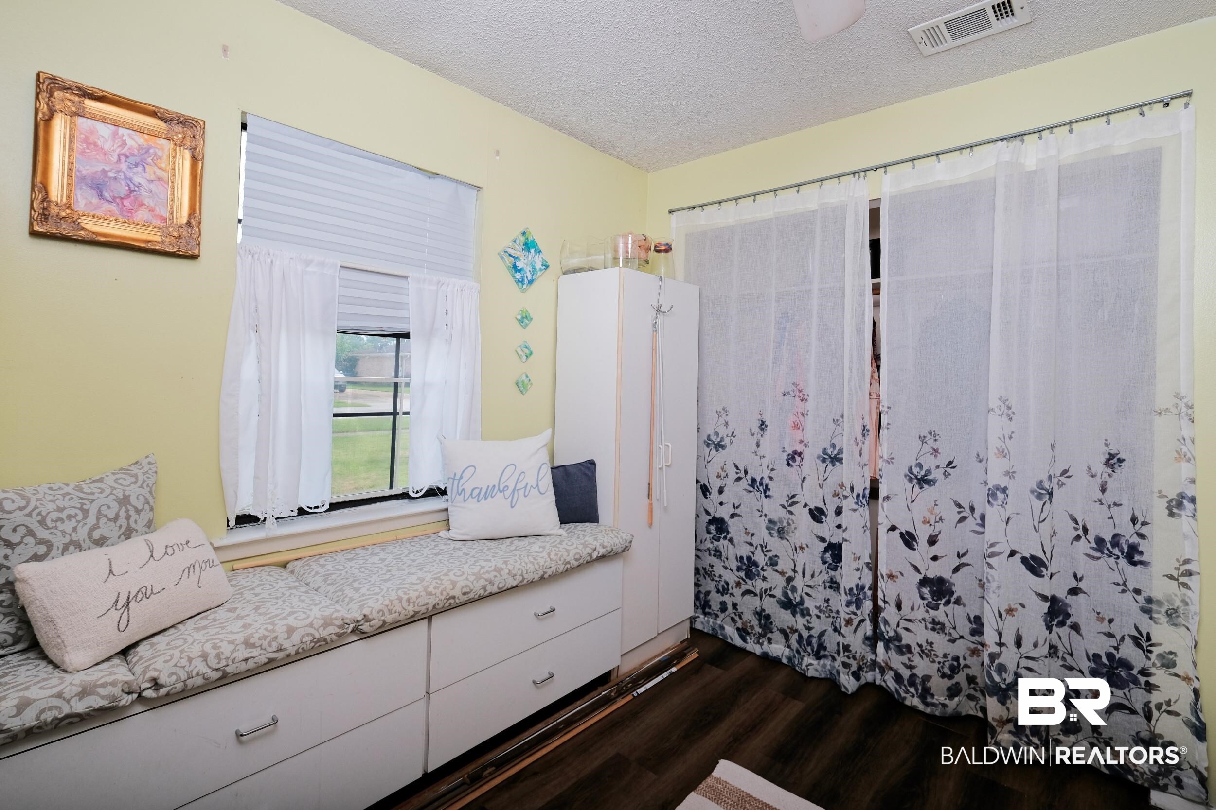 504 Ariel Avenue Foley, AL 36535 - Photo 33 of 33 Bedroom with dark wood-type flooring and a textured ceiling