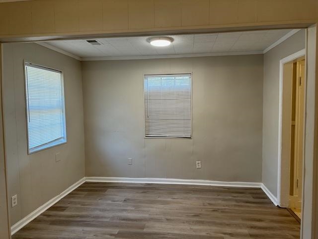 4571 Sea Isle Road Memphis, TN 38117 - Photo 7 of 12 an empty room with wooden floor and windows