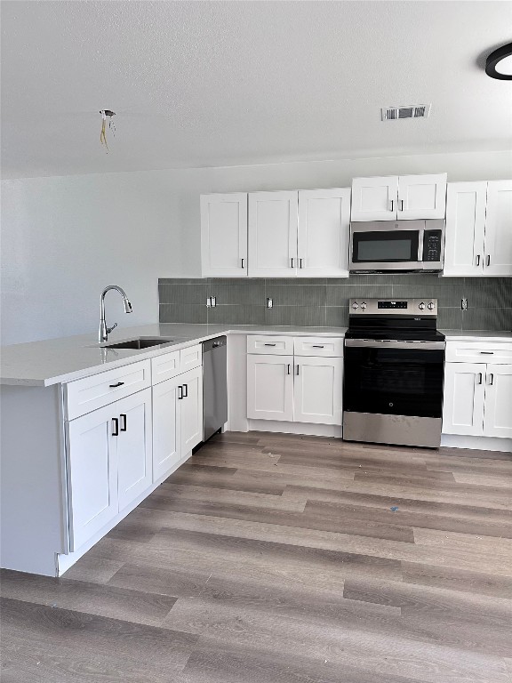 1830 River Crossing Circle, Unit C Austin, TX 78741 - Photo 4 of 16 a large white kitchen with stainless steel appliances granite countertop a stove a sink and white cabinets
