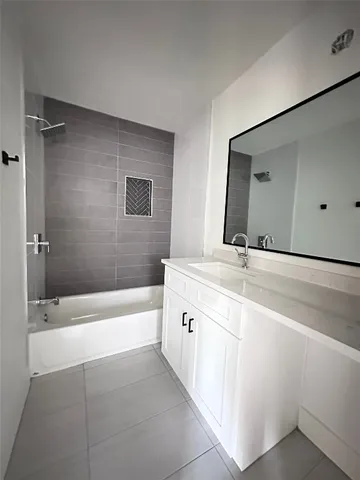 a bathroom with a bathtub sink and mirror