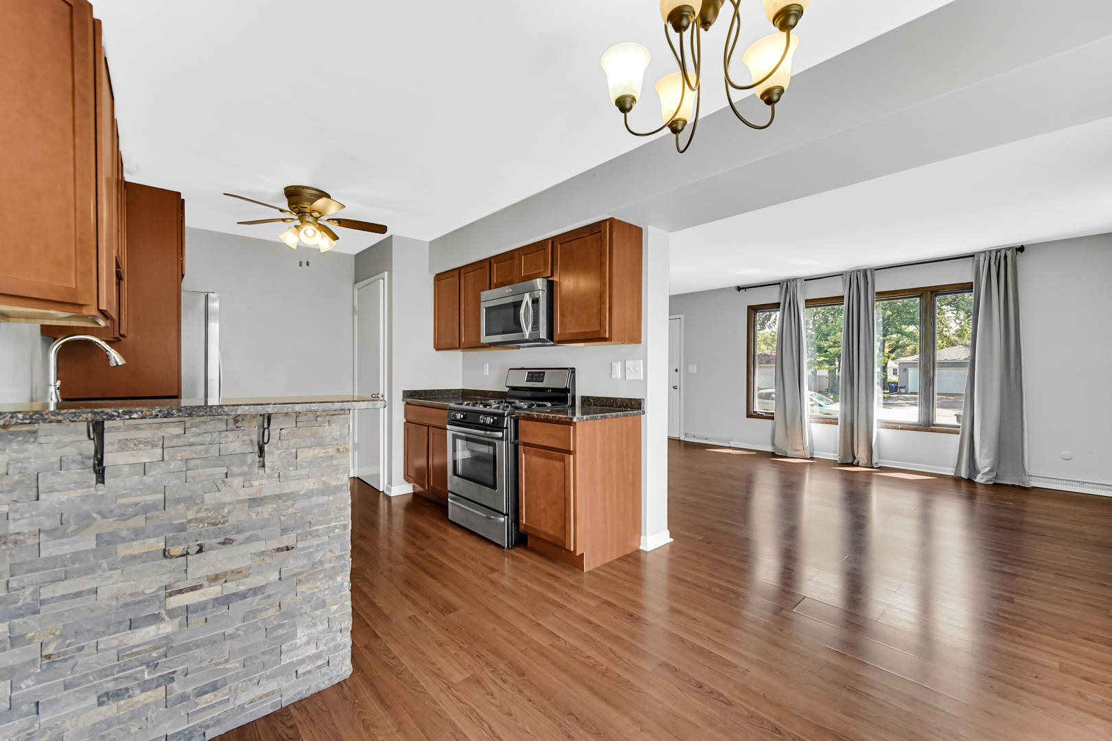 601 Northgate Road, Unit 601 New Lenox, IL 60451 - Photo 5 of 21 a kitchen with granite countertop a stove top oven and a sink with granite countertops