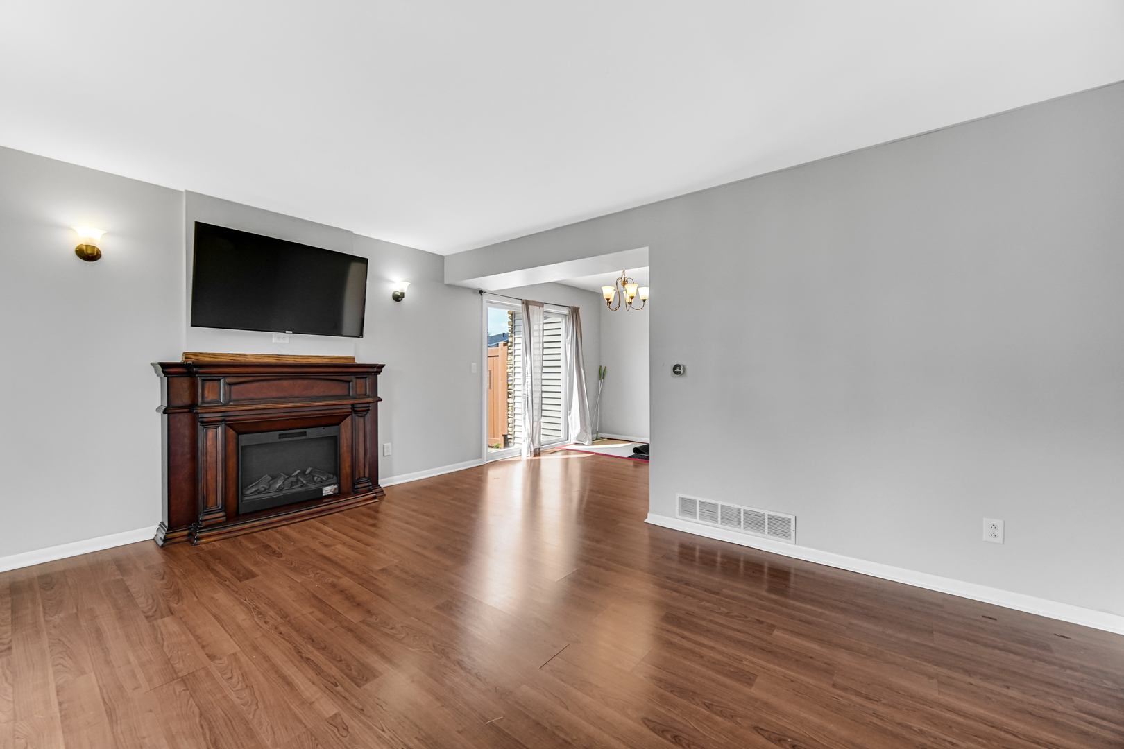 601 Northgate Road, Unit 601 New Lenox, IL 60451 - Photo 7 of 21 a view of an empty room with wooden floor fireplace and a window
