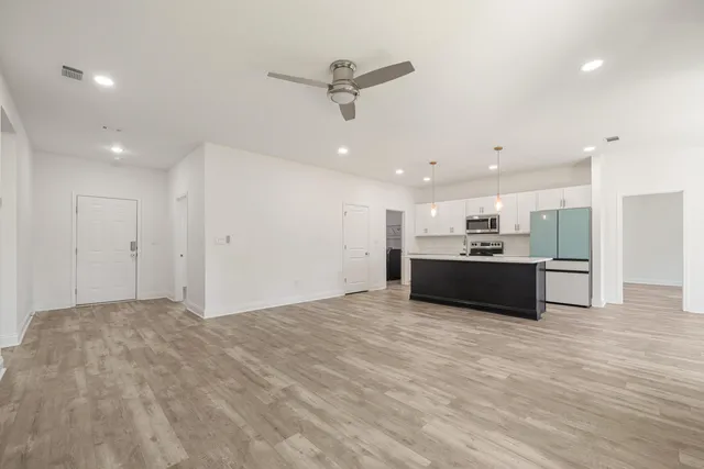 a kitchen with stainless steel appliances granite countertop a refrigerator a stove a sink and a microwave