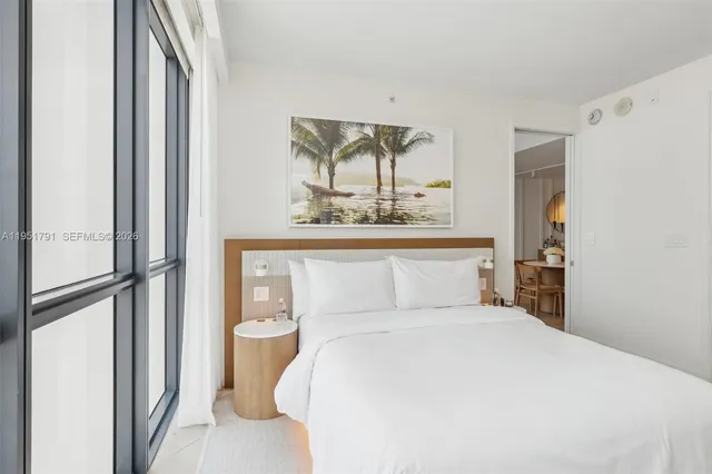 a bedroom with a bed and a painting on the wall