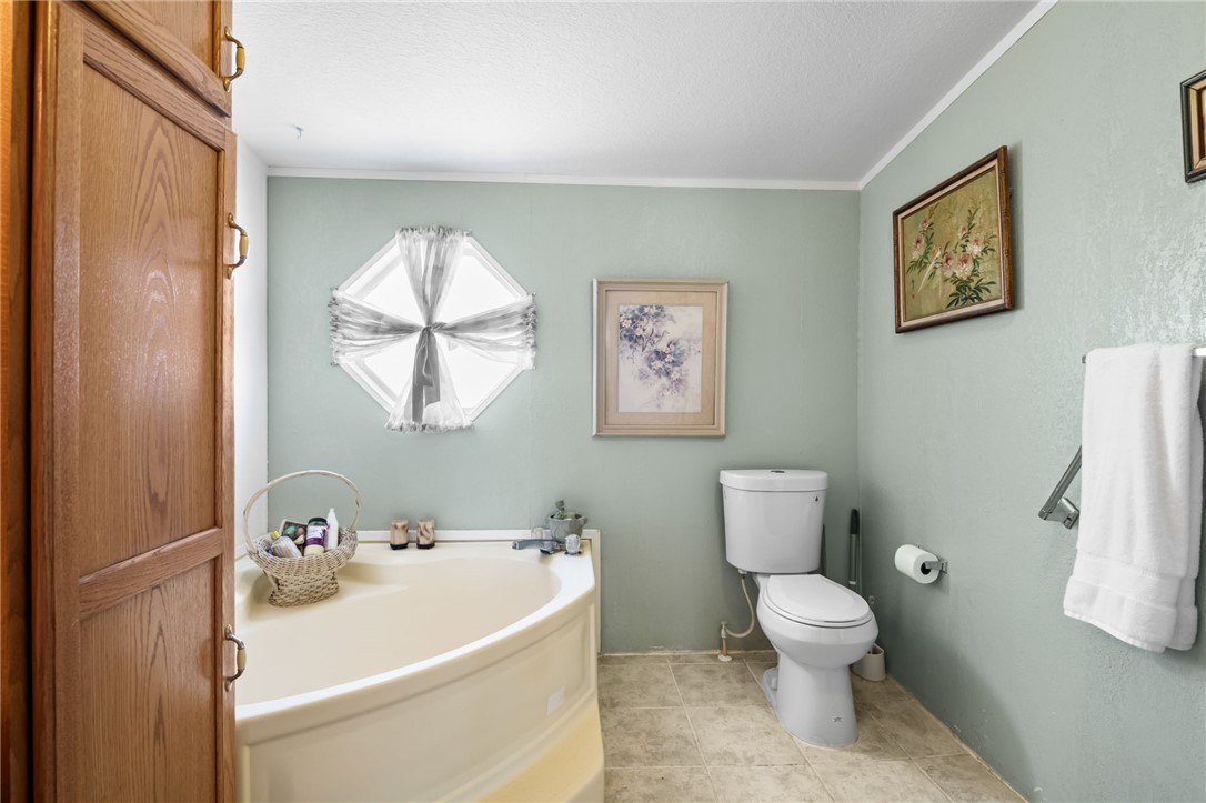 3411 Mayer Road Golden Valley, AZ 86413 - Photo 13 of 49 Bathroom featuring a garden tub, ornamental molding, and light tile patterned floors