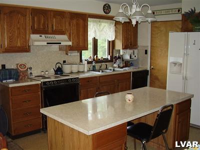 197 Belfast Road Wind Gap, PA 18091 - Photo 8 of 14 a kitchen with a sink a stove and wooden cabinets