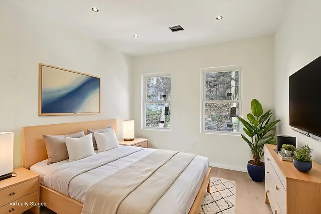 a bedroom with a large bed and a potted plant