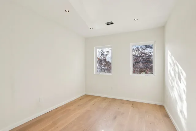 an empty room with closet and windows