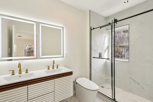 a bathroom with a granite countertop sink toilet and shower