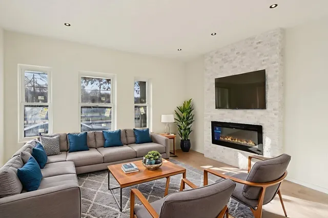 a living room with furniture a fireplace and a flat screen tv