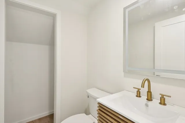 a bathroom with a sink a toilet and mirror