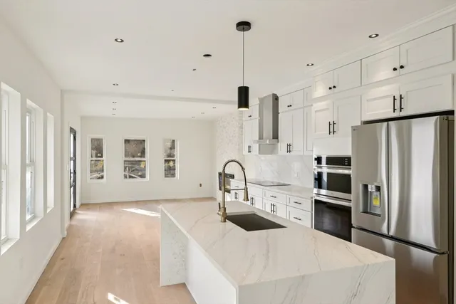 a kitchen with stainless steel appliances a refrigerator sink and cabinets