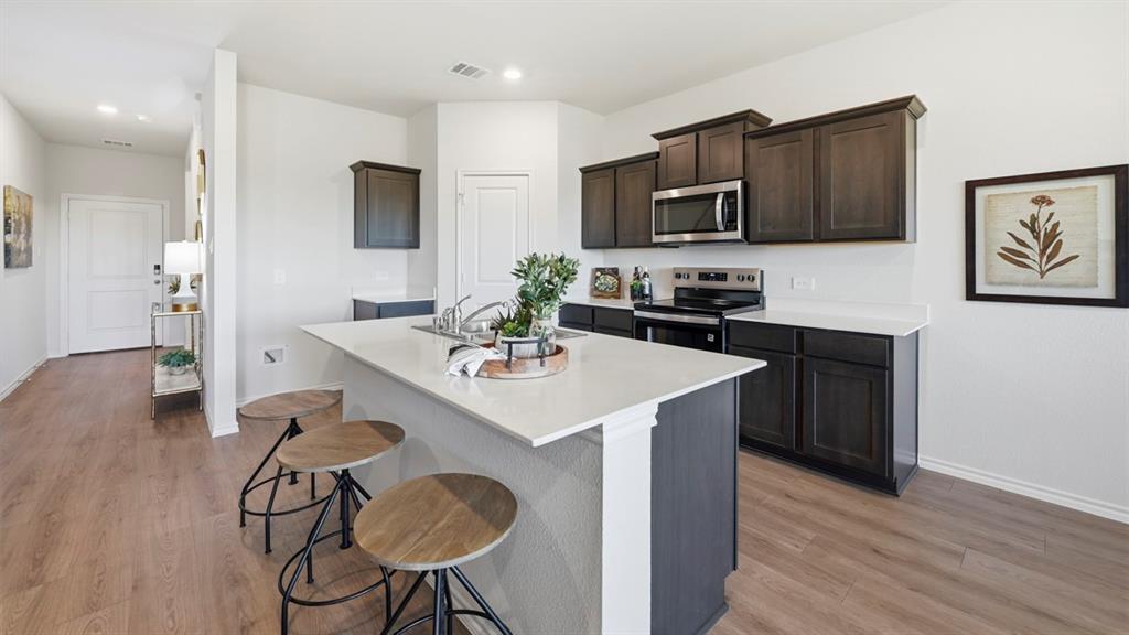 3435 Spur Run Sherman, TX 75090 - Photo 23 of 38 a kitchen with stainless steel appliances a sink a microwave refrigerator and cabinets