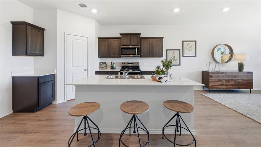 3435 Spur Run Sherman, TX 75090 - Photo 24 of 38 a living room with furniture a flat screen tv and kitchen view