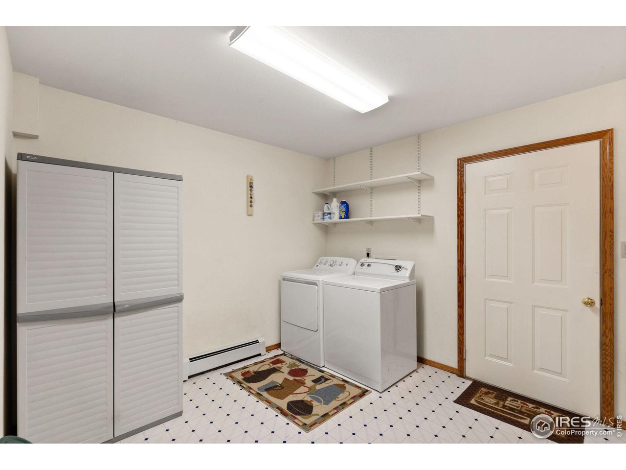 12492 Wasatch Road Longmont, CO 80504 - Photo 24 of 35 a utility room with cabinets washer and dryer
