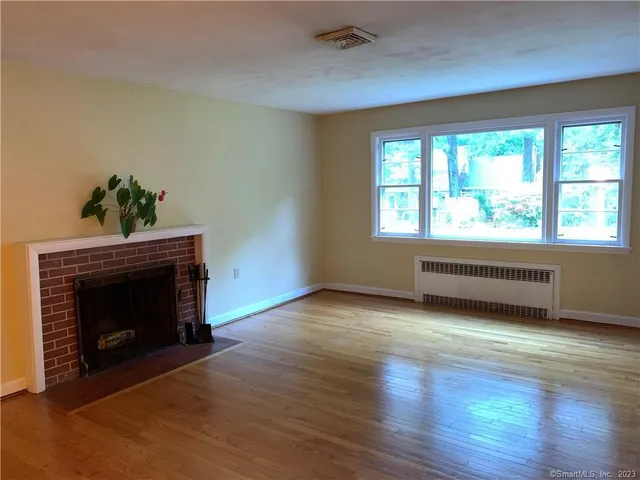 an empty room with windows and fireplace