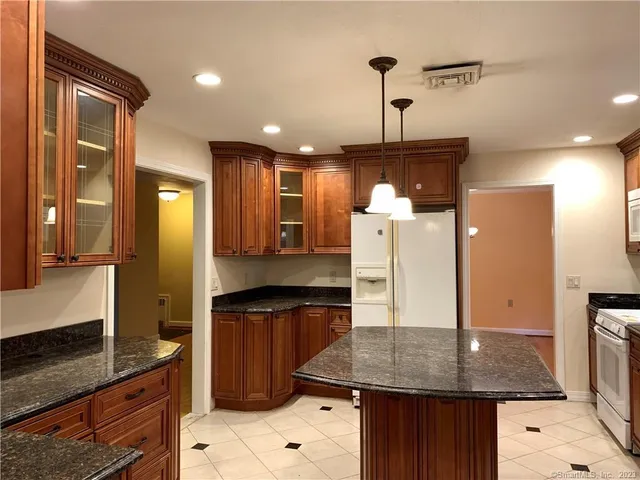 a kitchen with a refrigerator a sink and wooden cabinets