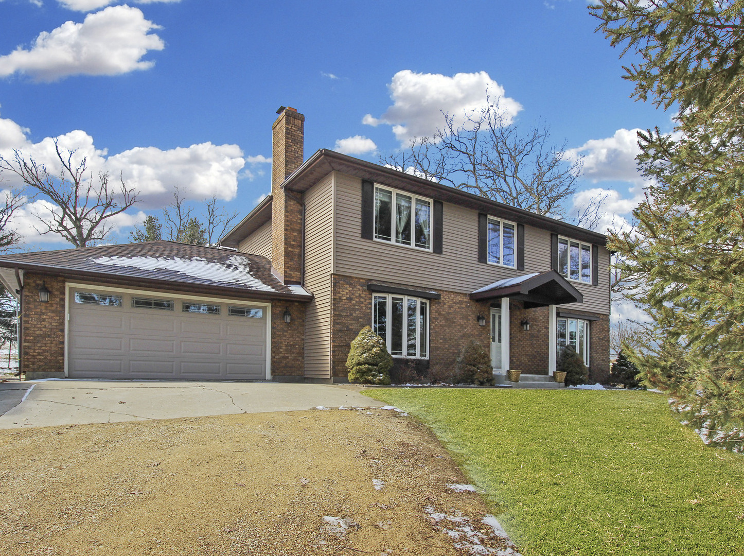 7417 East Maize Road Ridott, IL 61067 - Photo 2 of 46 a front view of a house with a yard and garage