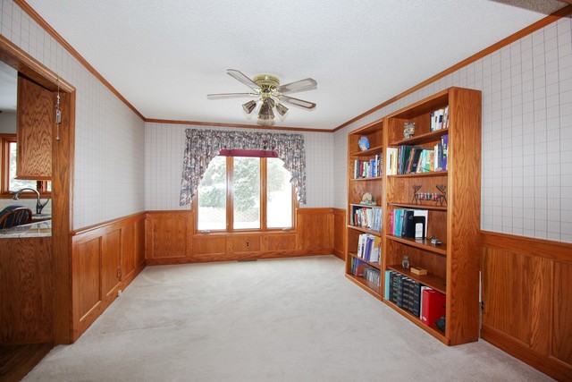 7417 East Maize Road Ridott, IL 61067 - Photo 16 of 46 an empty room with windows and book shelf