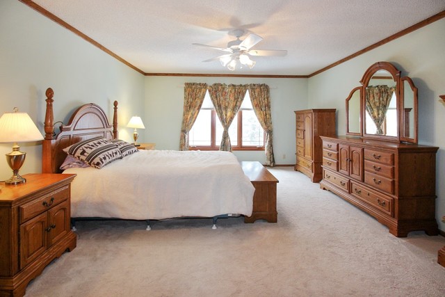 7417 East Maize Road Ridott, IL 61067 - Photo 22 of 46 a spacious bedroom with a bed a dresser next to a window