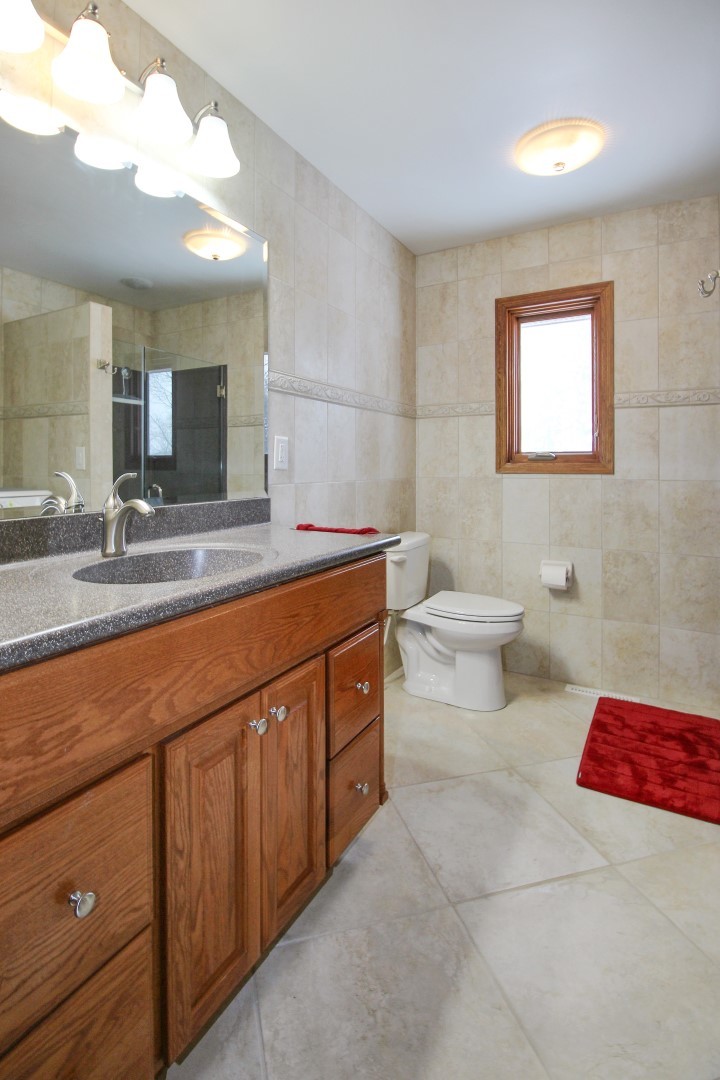 7417 East Maize Road Ridott, IL 61067 - Photo 29 of 46 a bathroom with a sink a toilet and mirror