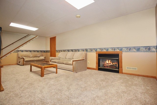 7417 East Maize Road Ridott, IL 61067 - Photo 36 of 46 a living room with furniture and a fireplace