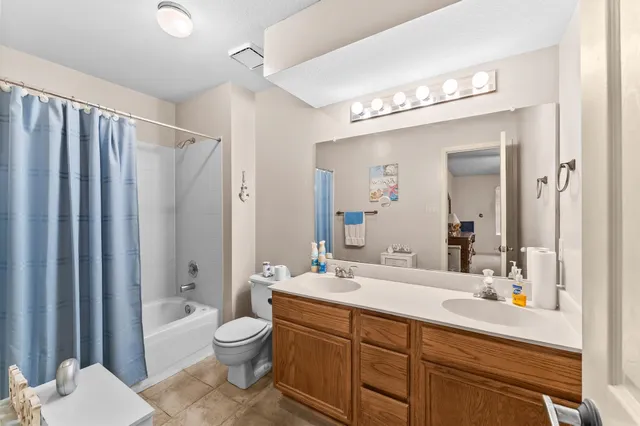 a bathroom with a granite countertop sink toilet a large mirror a bathtub and shower