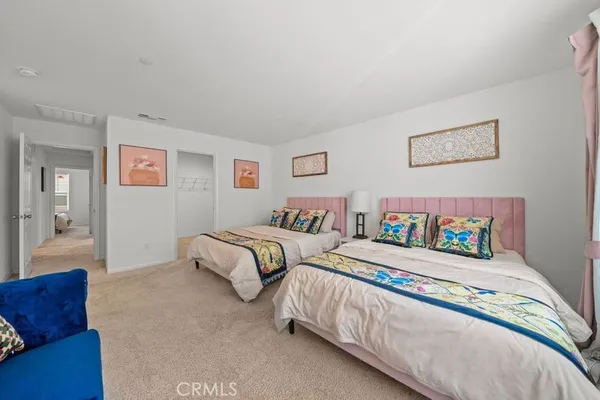 a bedroom with two beds and painting on the wall
