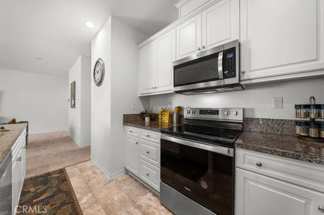 a kitchen with stainless steel appliances granite countertop a stove microwave and sink