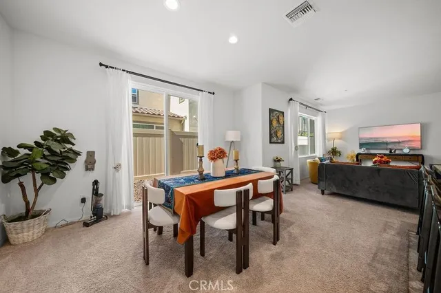 a living room with furniture a potted plant and a large window