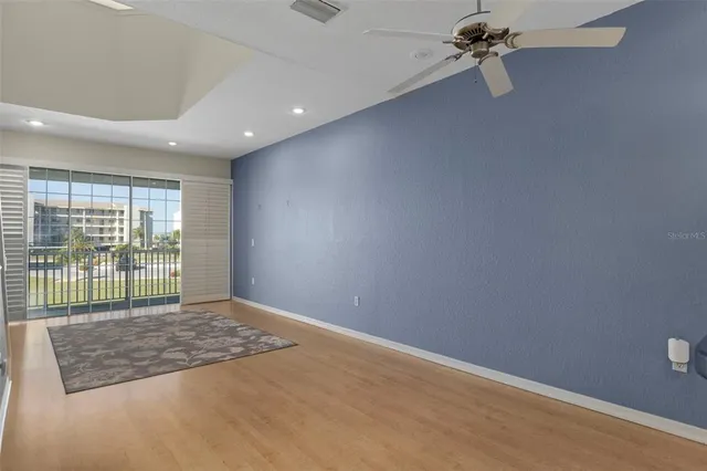 a view of a livingroom with wooden floor and a ceiling fan