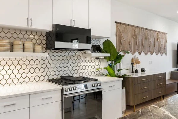 a kitchen with a stove and a white wooden cabinets