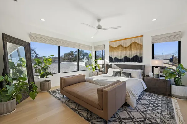 a bedroom with a large bed and a potted plant