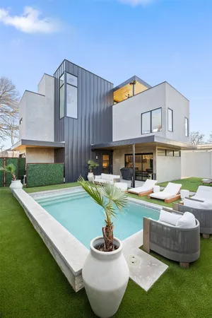 a front view of a house with swimming pool having outdoor seating