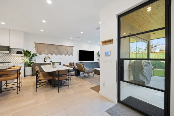a living room with furniture a flat screen tv and a large window