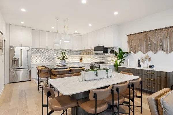 a kitchen with granite countertop a table chairs stove and refrigerator