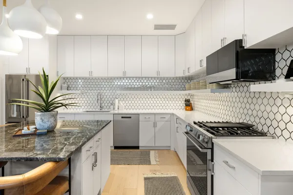 a kitchen with granite countertop a sink a stove and cabinets