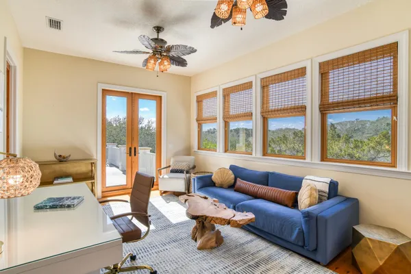 an empty room with wooden floor and ceiling fan