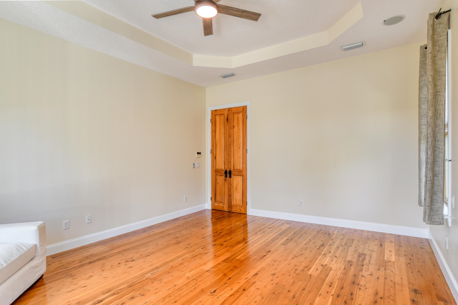 201 North Forest Dune Drive St. Augustine Beach, FL 32080 - Photo 39 of 57 an empty room with wooden floor and ceiling fan