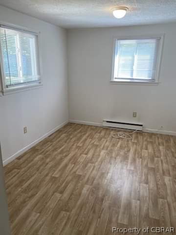 4187 River Road Lancaster, VA 22503 - Photo 4 of 7 Spare room featuring baseboard heating and hardwood / wood-style floors