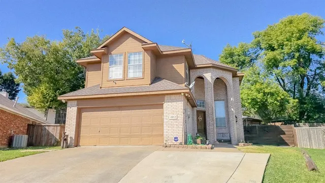 a front view of a house with a garden and garage